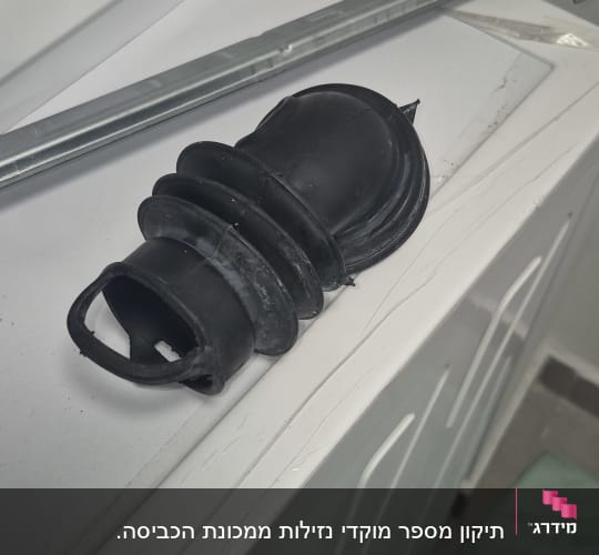 חלקי מכונת כביסה וכלי עבודה על מכסה מכונת כביסה